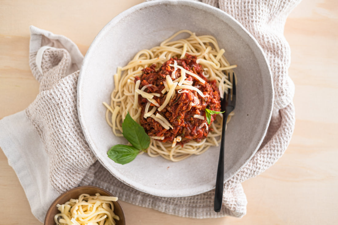 Spaghetti bolognese with fresh basil and grated cheese